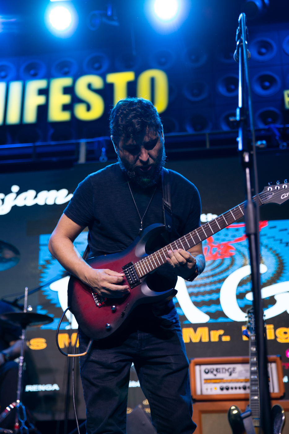Guitarrista do Bunkers ao vivo no Manifesto Bar, com painel de LED ao fundo